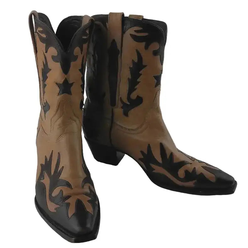 A pair of western-style boots with tan and black floral embroidery, shown against a neutral gray background.