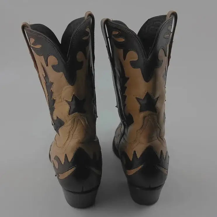A pair of cowboy boots shown from the back, featuring a tan and black western pattern with star and wave details, set against a plain gray background.