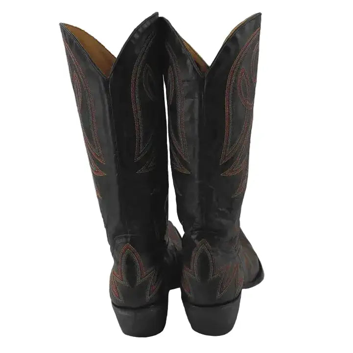 A pair of black leather cowboy boots shown from the back, featuring tan stitching and a tan interior lining, set against a plain gray background.