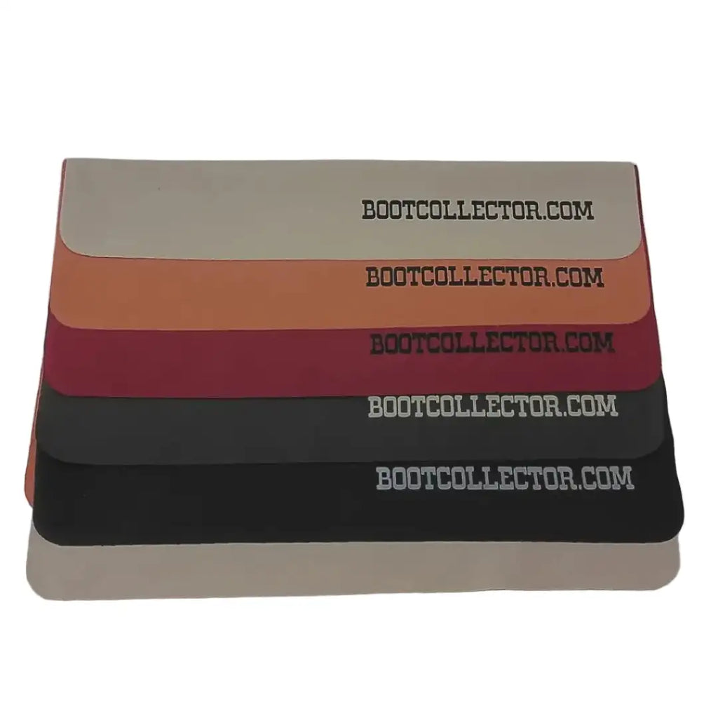 Five flat rectangular applicator cloths for shoe care, each with a curved top edge, in cream, orange, burgundy, dark gray, and black. Each card is printed with the text BOOTCOLLECTOR.