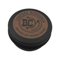 A round black metal tin with a brown circular label on top, photographed on a plain white background. The label reads 'LEATHER NOURISHER' and shows a central 'BC' logo with 'Bootcollector.com' beneath it.