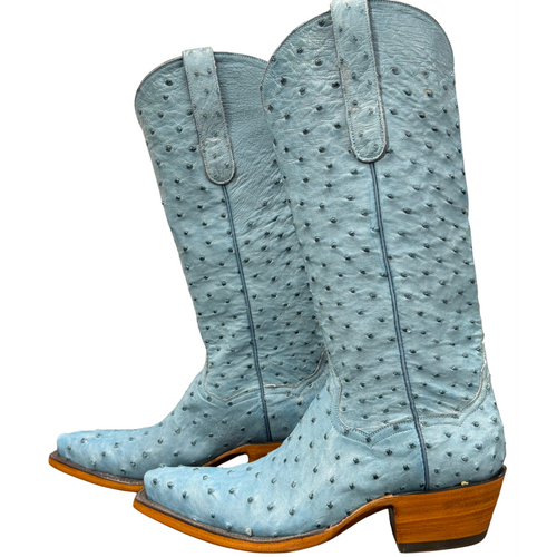 Light blue cowboy boots with brown soles on a white background