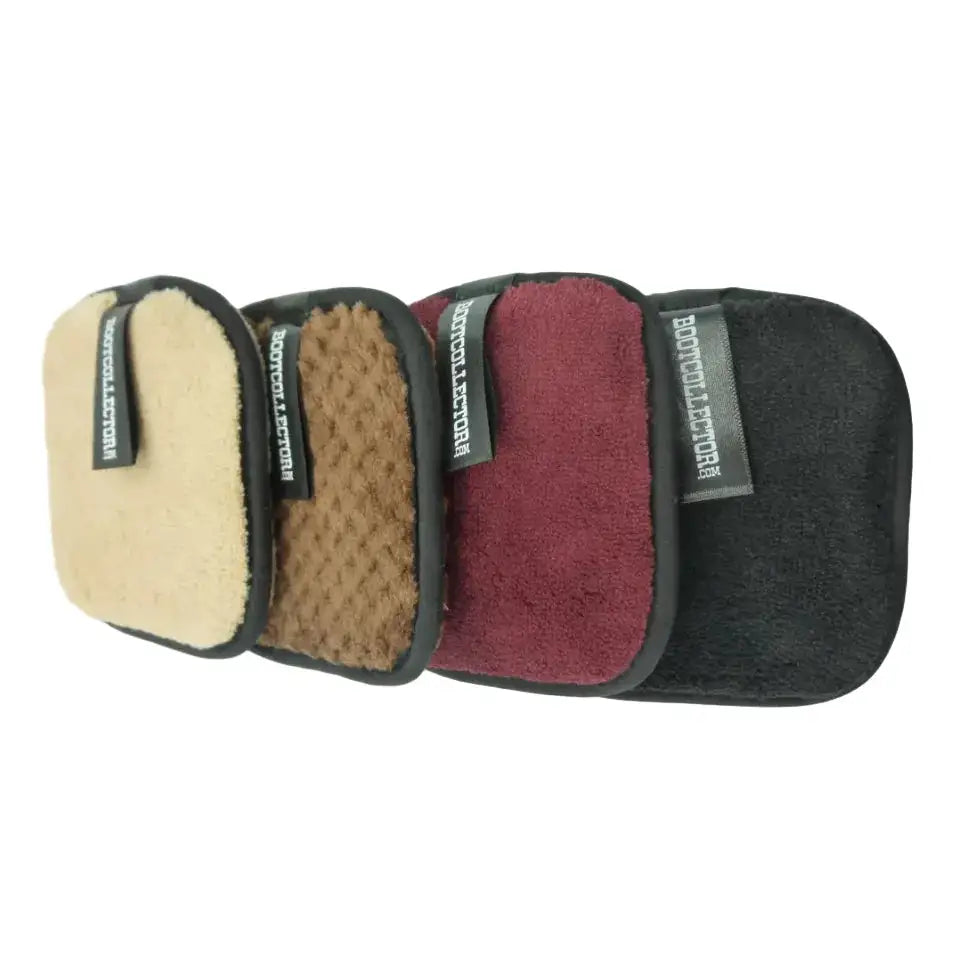 Four rectangular microfiber cleaning cloths in beige, brown, burgundy, and black, arranged in a fan shape on a white background. Each cloth has a black border and a small black brand tag reading 'BOTTLENECK LUXURY'.