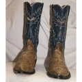 A pair of cowboy boots with dark navy blue shafts featuring gold western embroidery and a brown snakeskin-patterned foot, set against a draped white fabric background.